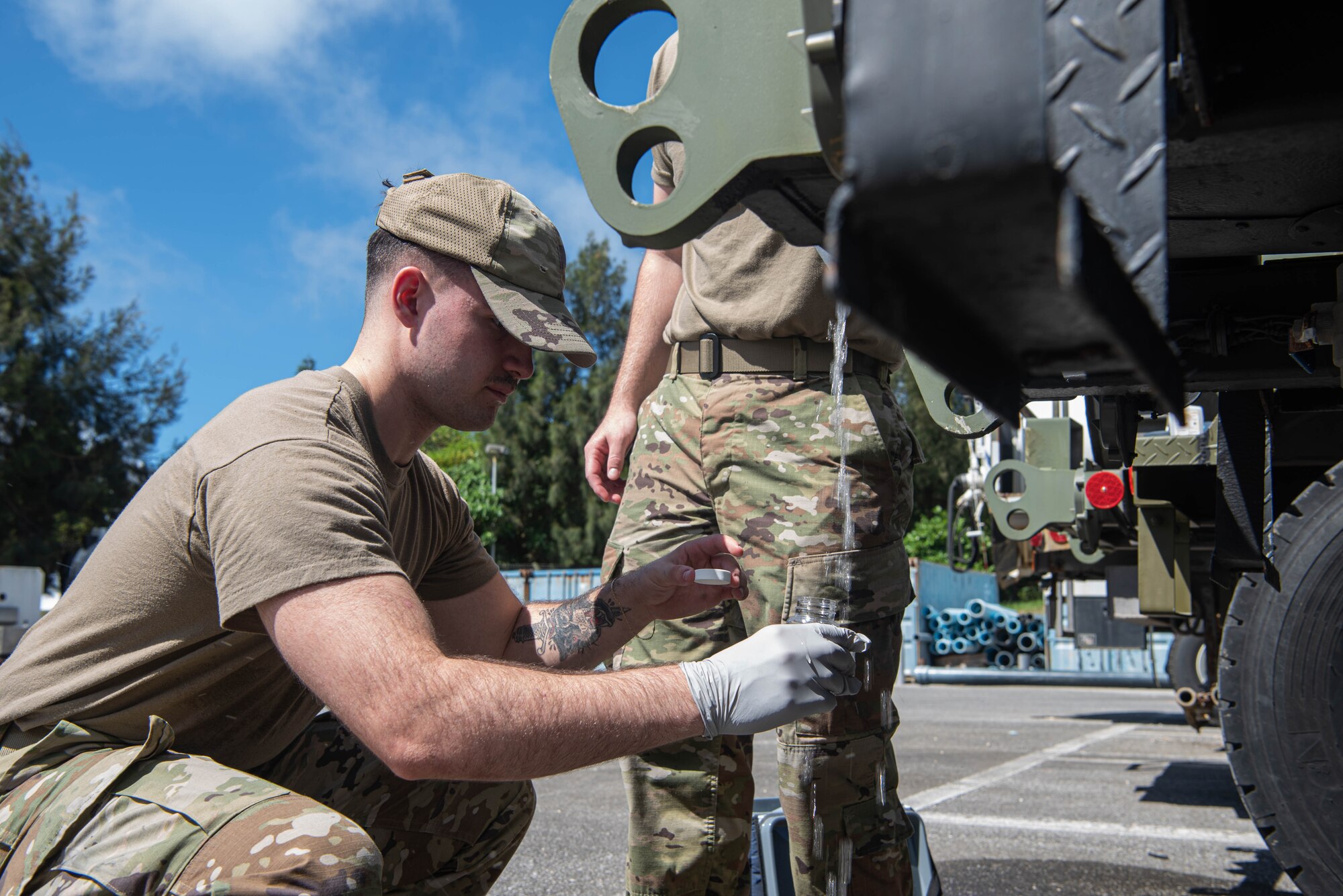 An Airman collects a water sample.