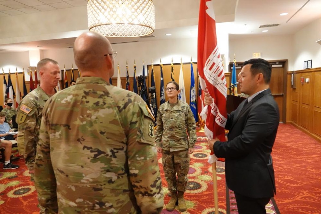 David Chai (right), U.S. Army Corps of Engineers (USACE) Far East District (FED) deputy district engineer and chief of program and project management division, prepares to pass the District colors to Col. Christopher W. Crary (center-left), who relinquishes command to Col. Heather A. Levy (center-right), USACE FED commander, during a change of command ceremony held at River Bend Golf Course, USAG Humphreys, Republic of Korea, July 19. Brig. Gen. Kirk E. Gibbs (left), USACE Pacific Ocean Division command general, presided over the ceremony. (Photo Credit: Susan Lee)