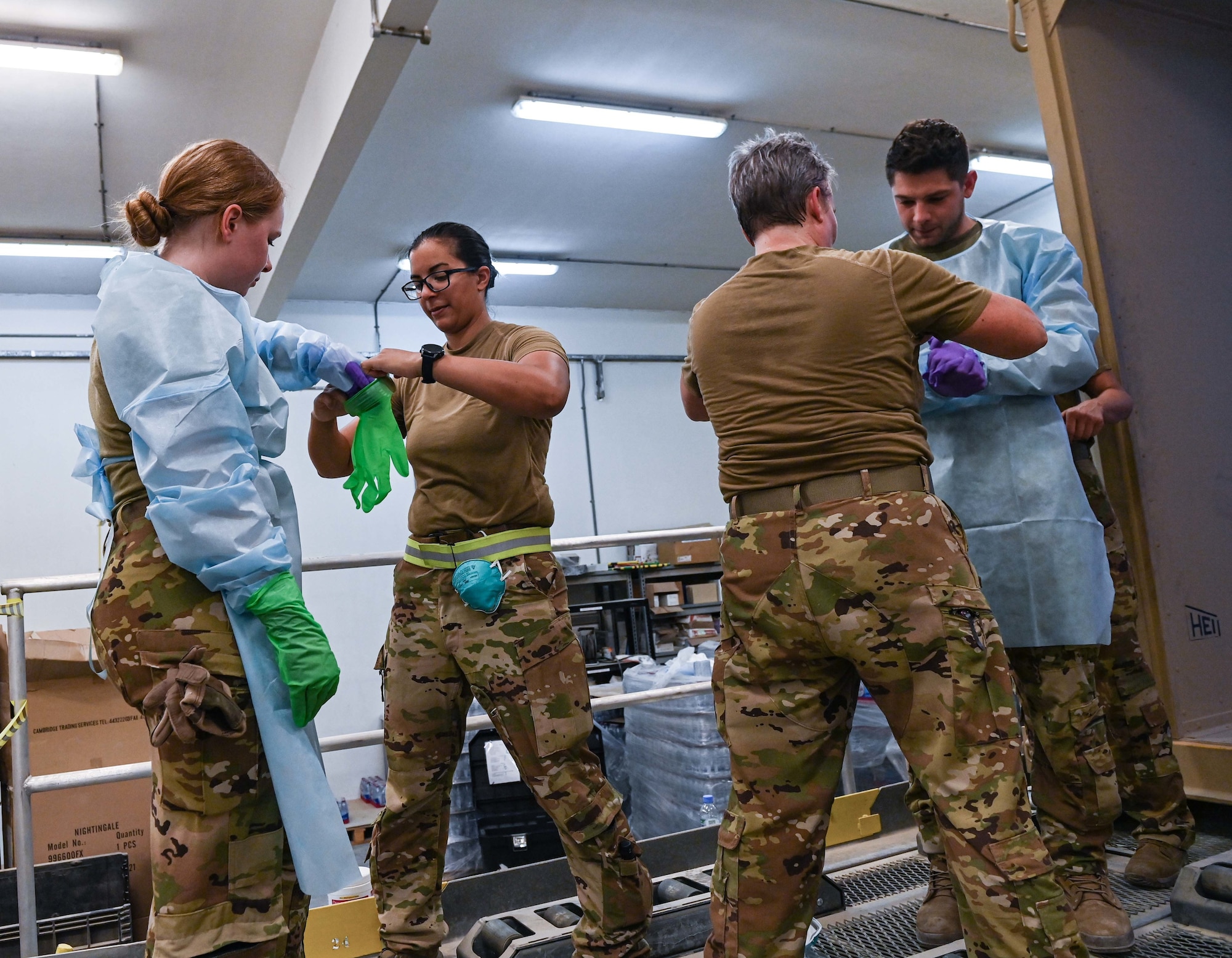 379th Expeditionary Air Evacuation Squadron airmen don personal protective equipment during a medical exercise July 11, 2022 at Al Udeid Airbase, Qatar. The exercise provided the medical evacuation staff the opportunity to practice procedures for transporting highly contagious patients to medical facilities. (U.S. Air National Guard photo by Tech. Sgt. Michael J. Kelly)