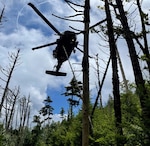 A Tennessee Army National Guard UH-60 Black Hawk helicopter aircrew prepares to hoist a hiker with a life-threatening illness and a Tennessee National Guard flight paramedic into the helicopter on Mount LeConte at the Great Smoky Mountains National Park area July 19.