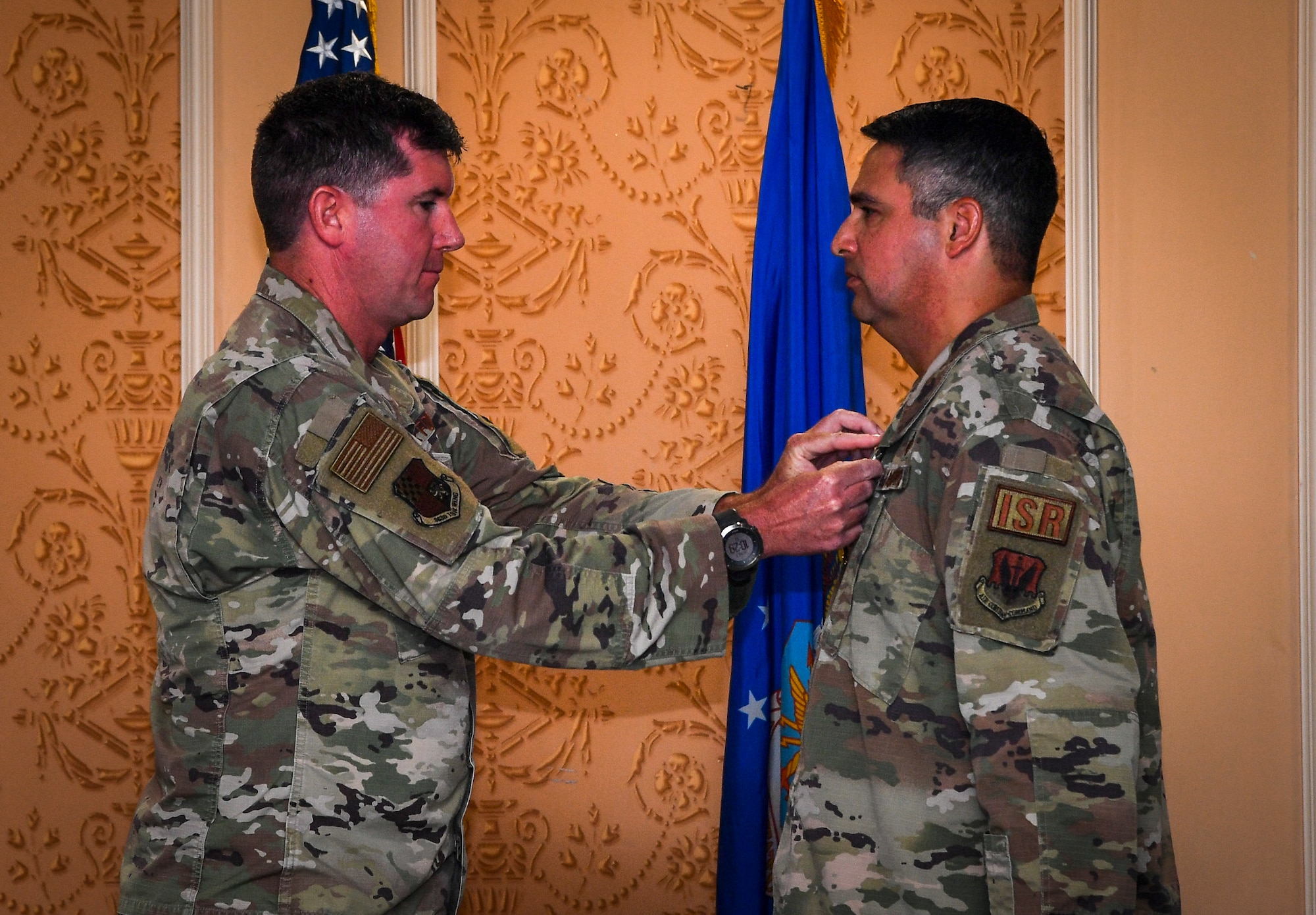 An Airman pins an award on another Airman.