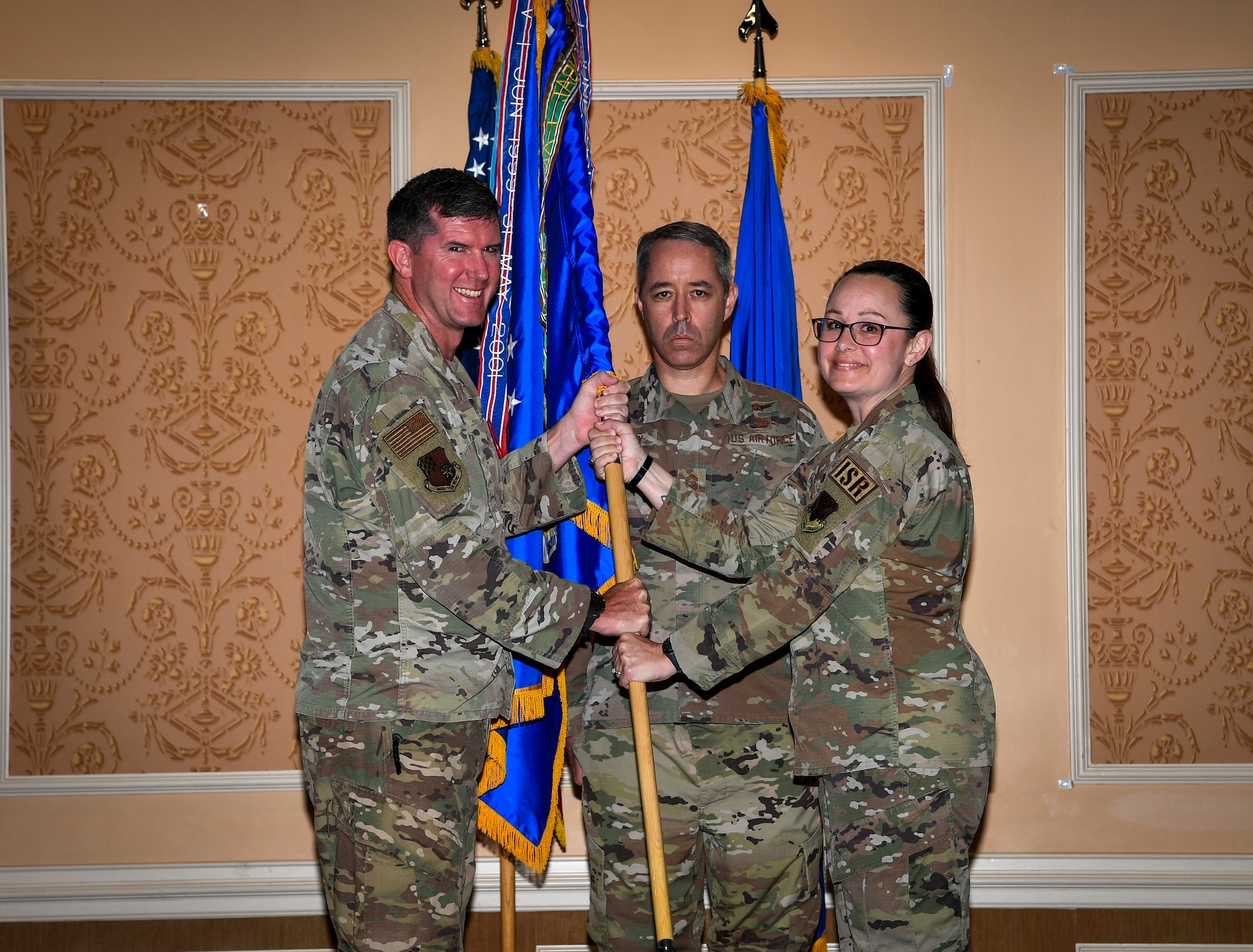 Photo of two individuals holding a unit flag.