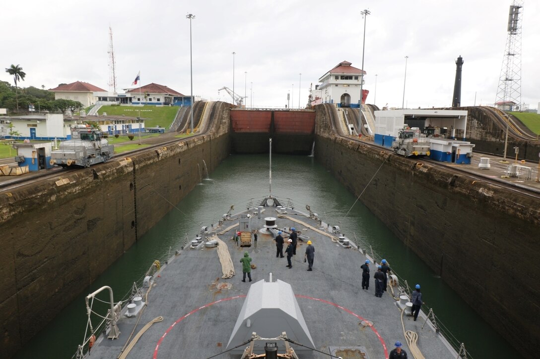 A large boat waits in a lock on a waterway.