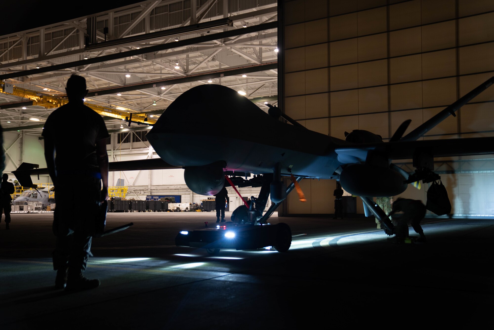 MARINE CORPS BASE HAWAII, Hawaii (July 13, 2022) - U.S. Air Force maintenance specialists, assigned to the 29th Air Maintenance Unit, tow the MQ-9A Reaper at Marine Corps Air Station Kaneohe Bay during Rim of the Pacific (RIMPAC) 2022, July 13. Unmanned and remotely operated vessels extend the capability of interconnected manned platform sensors to enhance the warfighting capacity of multinational joint task forces. Twenty-six nations, 38 ships, four submarines, more than 170 aircraft and 25,000 personnel are participating in RIMPAC from June 29 to Aug. 4 in and around the Hawaiian Islands and Southern California. The world's largest international maritime exercise, RIMPAC provides a unique training opportunity while fostering and sustaining cooperative relationships among participants critical to ensuring the safety of sea lanes and security on the world's oceans. RIMPAC 2022 is the 28th exercise in the series that began in 1971. (U.S. Air Force photo by Airman 1st Class Ariel O'Shea)