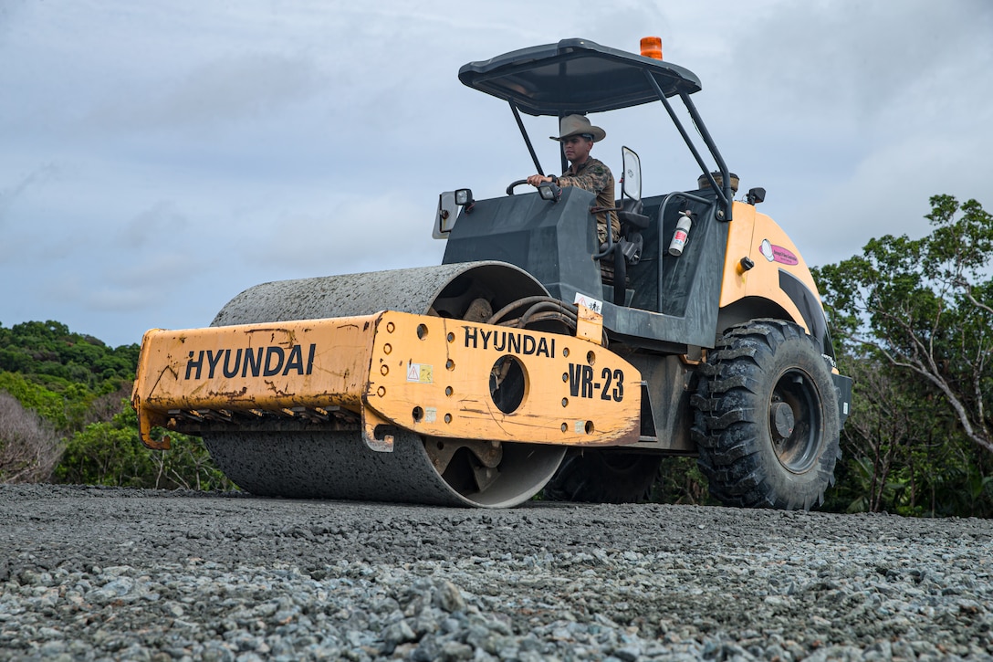U.S. Marine Corps Pfc. Brayan Cordovagonzalez, a heavy equipment operator with Task Force Koa Moana 22, I Marine Expeditionary Force, flattens gravel using a compactor during the construction of the Joint Range Complex in Ngchesar, Republic of Palau, July 5, 2022. The Joint Range Complex will provide the U.S. military and Palauan law enforcement agencies a place to sharpen their skills and improve marksmanship capabilities, strengthening readiness and interoperability in support of U.S. Indo-Pacific Command’s strategic and operational objectives.