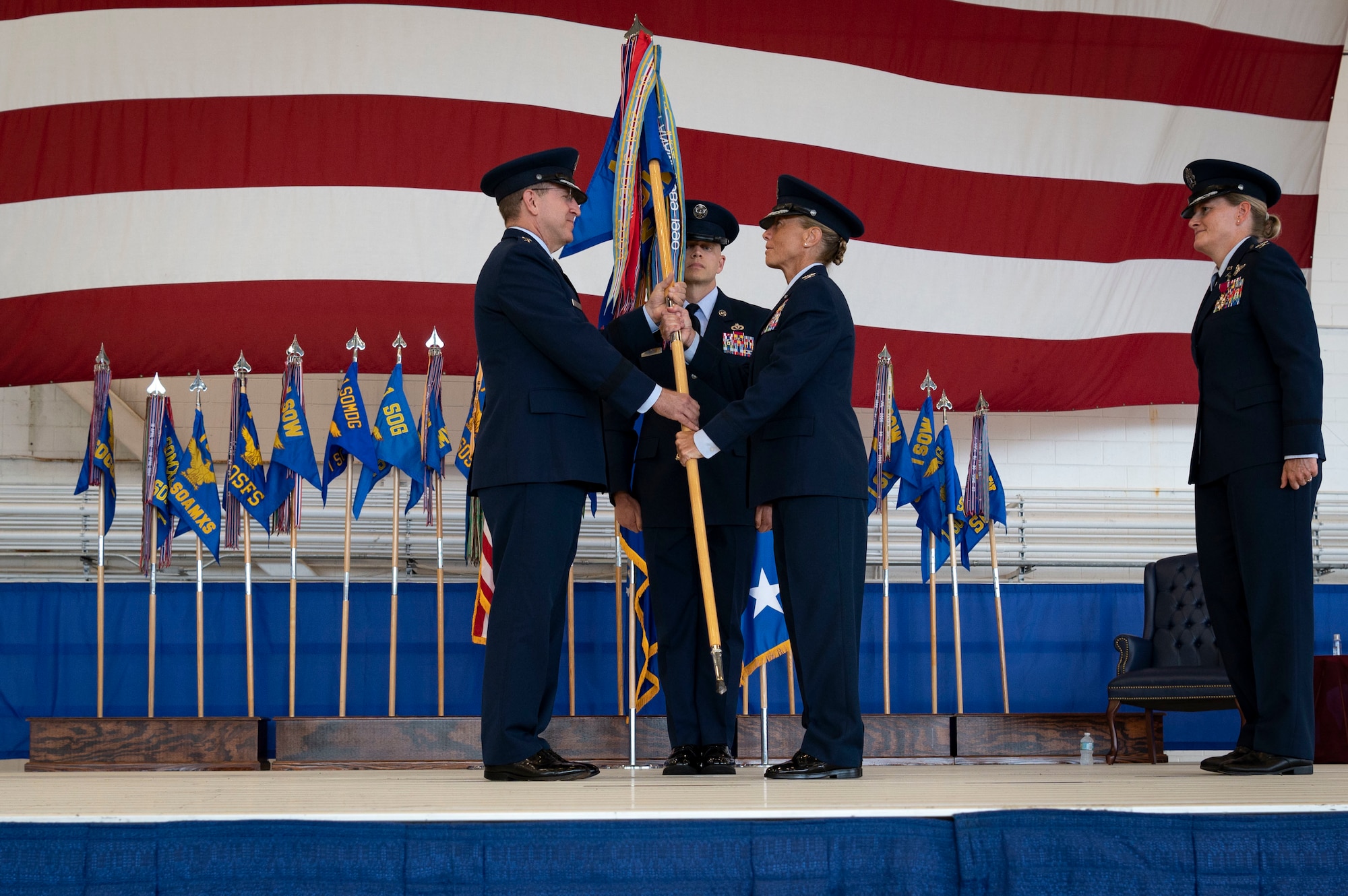 U.S. Air Force Lt. Gen. Jim Slife, commander of Air Force Special Operations Command, passes the 1st Special Operations Wing guidon to U.S. Air Force Col. Allison Black during the 1st SOW change of command ceremony at Hurlburt Field, Florida, July 21, 2022