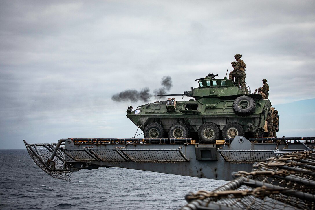 A light armored vehicle fires its weapon from a ship.