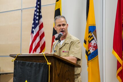 Capt. Eric Correll standing in front of podium giving opening remarks