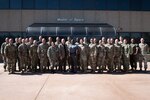 A group of 30 military members in uniform pose for a group photo
