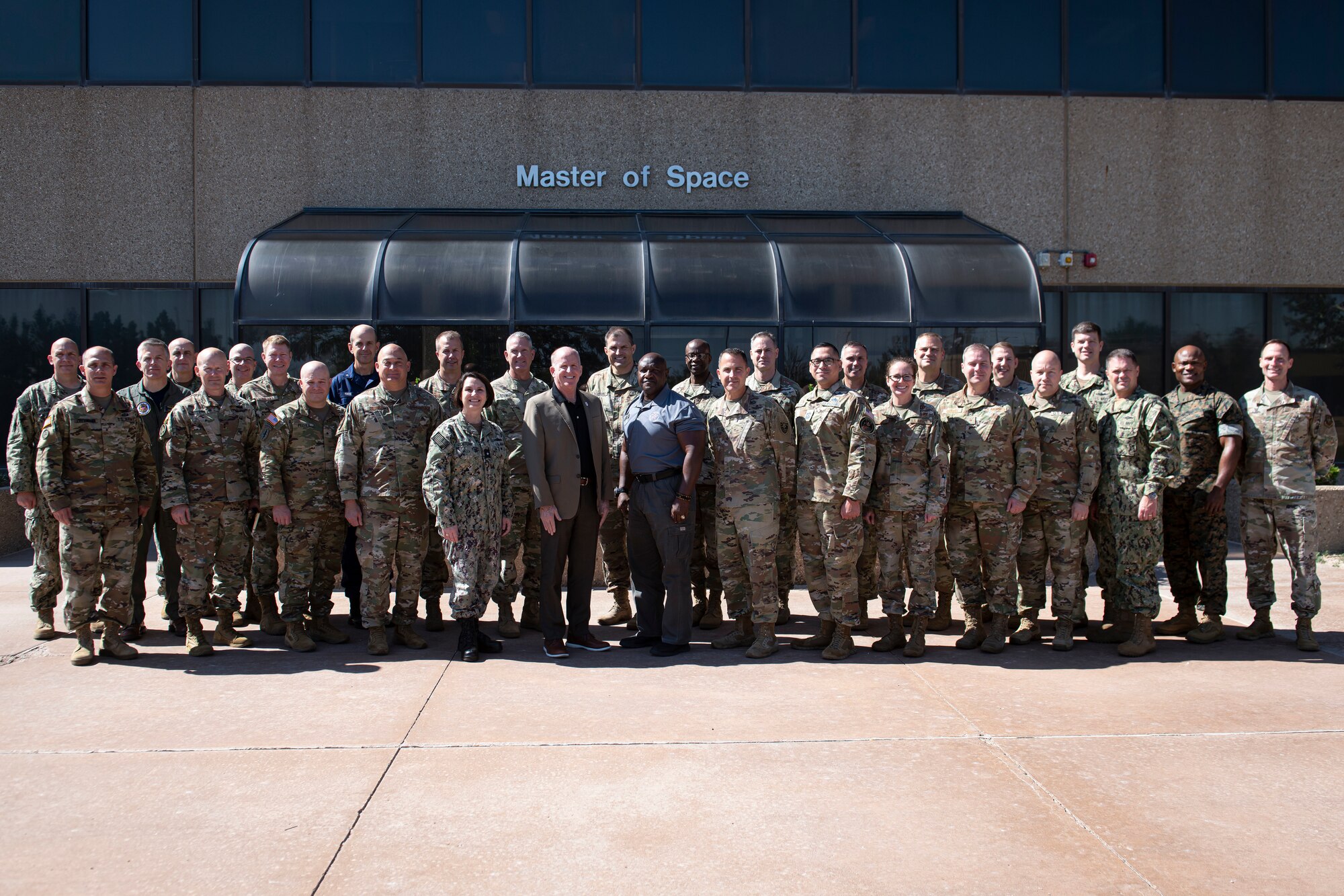 A group of 30 military members in uniform pose for a group photo
