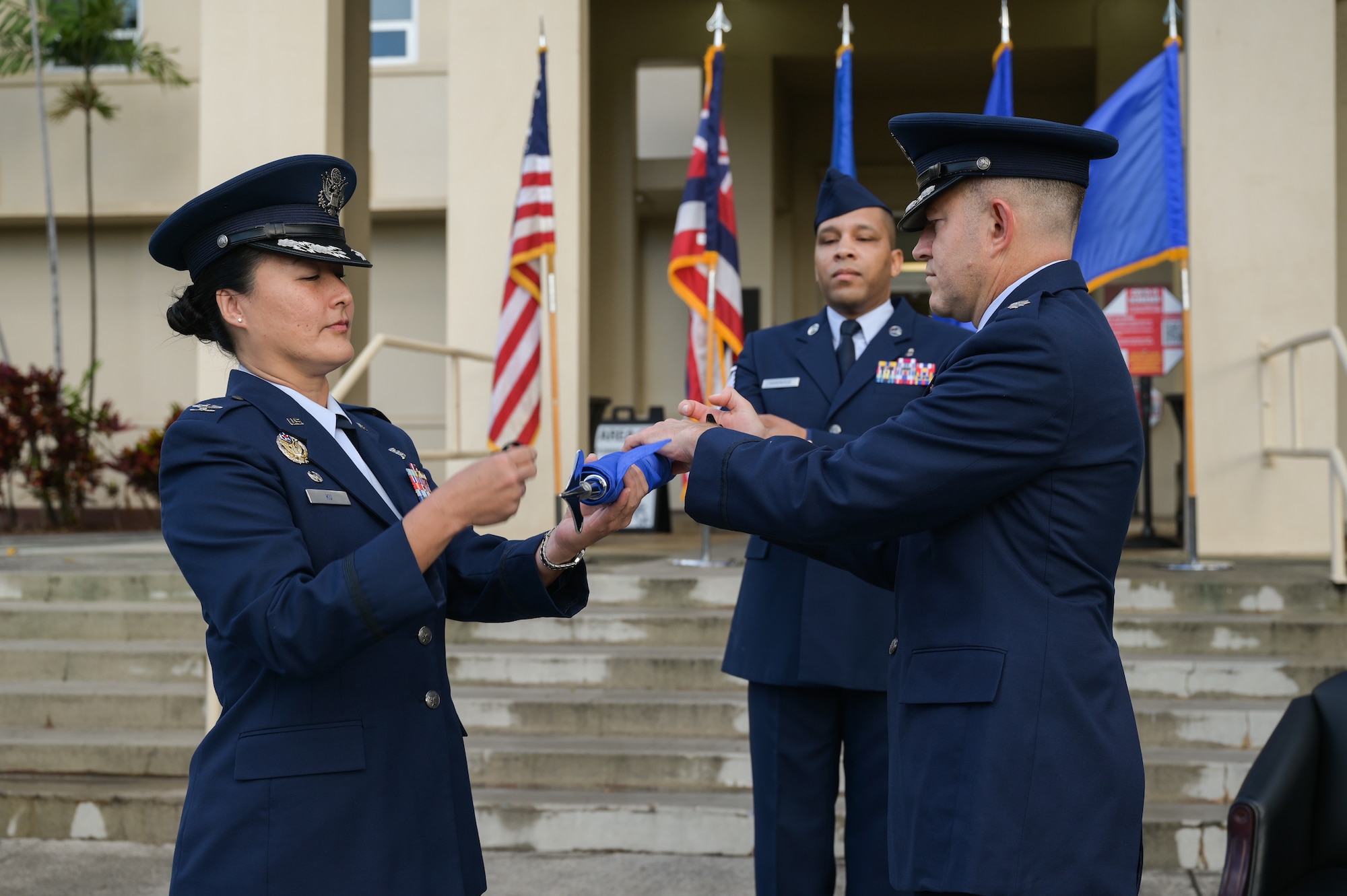 Col. Stephanie Ku, 15th Medical Group commander, and Lt. Col. Joseph Sanchez, 15th Healthcare Operations Squadron incoming commander, furl the 15th Medical Support Squadron guidon during a deactivation ceremony at Joint Base Pearl Harbor-Hickam, Hawaii, July 21, 2022. The 15th HCOS is one of the three squadrons that are a part of the 15th MDG. (U.S. Air Force photo by Staff Sgt. Alan Ricker)