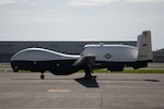 A MQ-4C on the runway at Marine Corps Air Station Iwakuni, Japan, July 13, 2022. The MQ-4C is on a deployment to MCAS Iwakuni in support of continuing operations in the Indo-Paciﬁc area of operations. The 