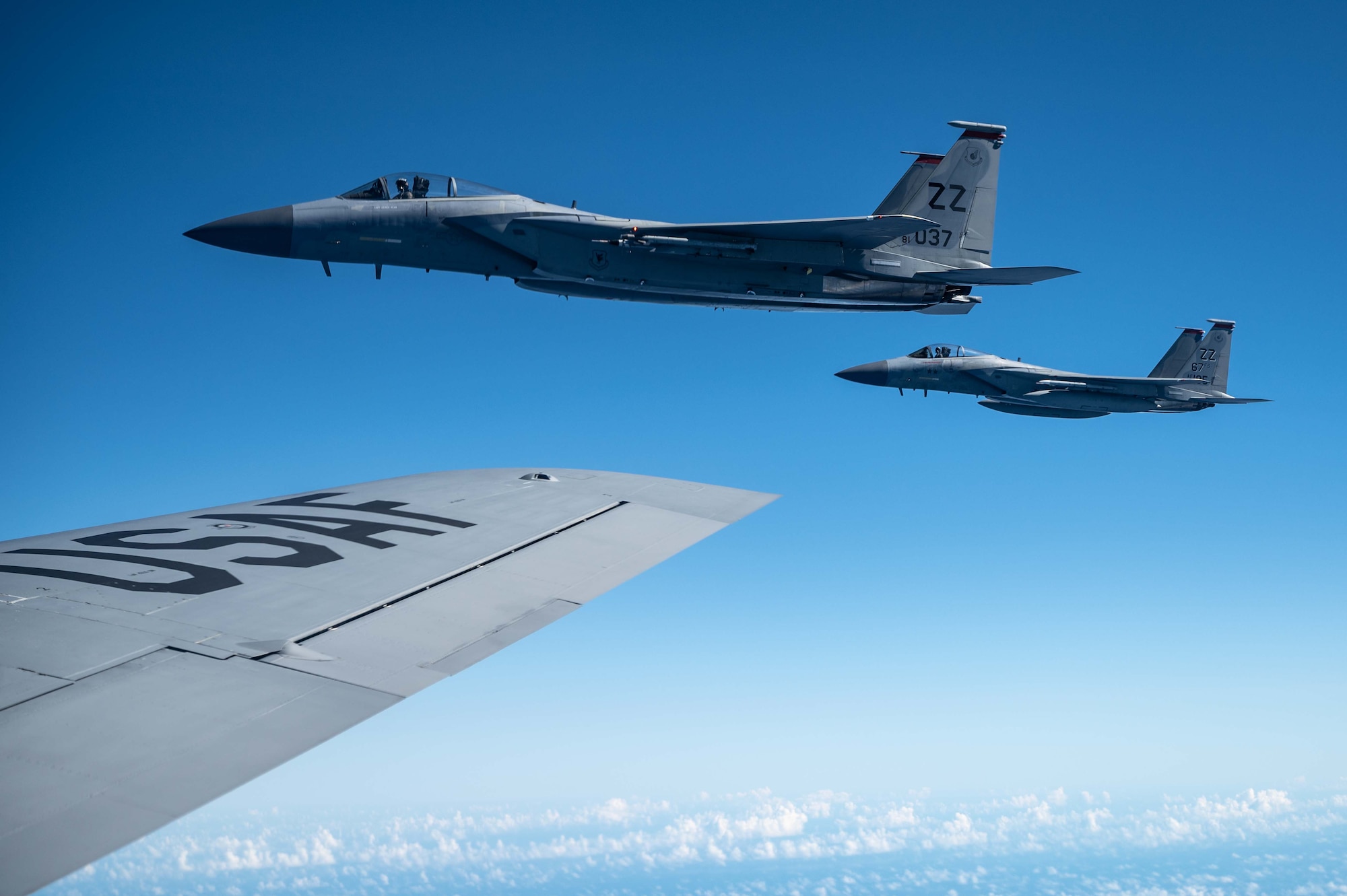 Two F-15s fly next to a KC-135