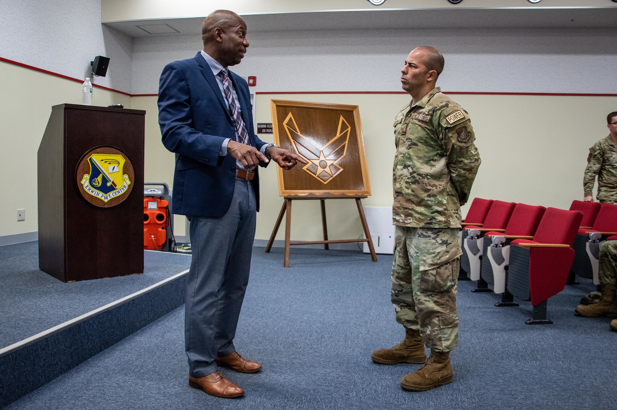 Retired Airman speaks to an Airman.