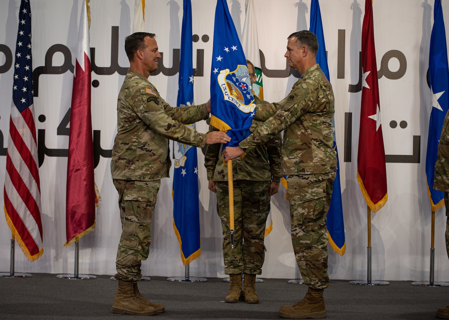 U.S. Army Gen. Michael E. Kurilla, U.S. Central Command commander, passes the ceremonial guidon to U.S. Air Force Lt. Gen. Alexus G. Grynkewich, incoming commander of Ninth Air Force (Air Forces Central) during a change of command ceremony at Al Udeid Air Base, Qatar, July 21, 2022. Grynkewich will serve as the commander of AFCENT and the combined forces air component, working closely with coalition, joint, and interagency partners to lead a combined force that delivers decisive airpower and promotes security throughout U.S. CENTCOM’s 21-nation area of responsibility. (U.S. Air Force photo by Staff Sgt. Draeke Layman)