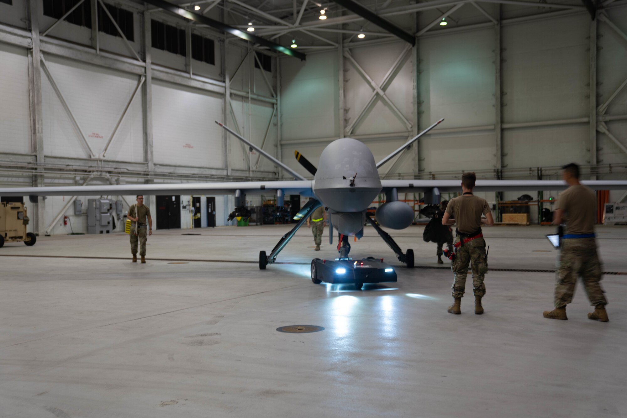 MARINE CORPS BASE HAWAII, Hawaii (July 13, 2022) - U.S. Air Force maintenance specialists, assigned to the 29th Air Maintenance Unit, tow the MQ-9A Reaper through the hangar at Marine Corps Air Station Kaneohe Bay during Rim of the Pacific (RIMPAC) 2022, July 13. Unmanned and remotely operated vessels extend the capability of interconnected manned platform sensors to enhance the warfighting capacity of multinational joint task forces. Twenty-six nations, 38 ships, four submarines, more than 170 aircraft and 25,000 personnel are participating in RIMPAC from June 29 to Aug. 4 in and around the Hawaiian Islands and Southern California. The world's largest international maritime exercise, RIMPAC provides a unique training opportunity while fostering and sustaining cooperative relationships among participants critical to ensuring the safety of sea lanes and security on the world's oceans. RIMPAC 2022 is the 28th exercise in the series that began in 1971. (U.S. Air Force photo by Airman 1st Class Ariel O'Shea)
