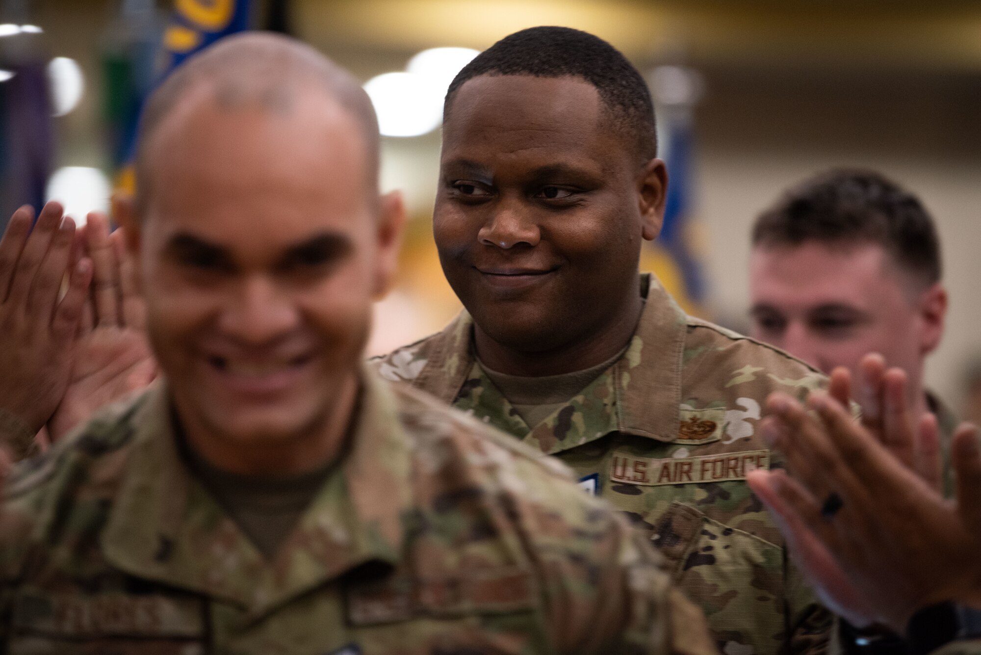 Staff Sgt. Odency Johnson, 607th Air Communications Squadron command and control theater battle management core systems supervisor, smiles as Airmen congratulate him during a technical sergeant promotion release ceremony at Osan Air Base, Republic of Korea, July 21, 2022.