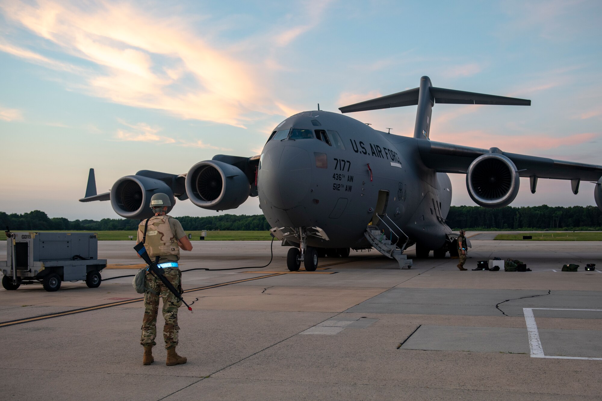 U.S. Air Force Master Sgt. Christopher C. Mood Jr., 712th Aircraft Maintenance Squadron maintainer, waits to signal another maintainer during routine maintenance of a C-17 Globemaster III during the Liberty Eagle Readiness Exercise at Dover Air Force Base, Delaware, July 15, 2022. Mood is one of many maintainers from the 512th and 436th airlift wings who demonstrated their ability to conduct aircraft maintenance while wearing mission oriented protective posture gear at a simulated forward operating base, located on Dover AFB, July 11-15, 2022. The purpose of this exercise was to validate both wings' ability to generate, employ and sustain airpower across the world in a contested and degraded operational environment. (U.S. Air Force photo by Senior Airman Ruben Rios)