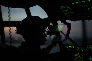A pilot flies at night using night vision goggles.