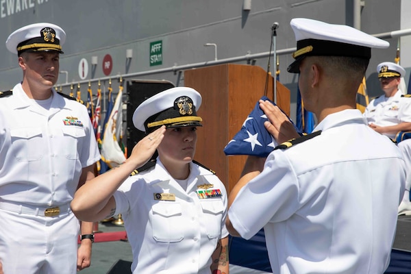 Lt. j.g. Ashley Lewis renders honors to the Ensign during a Commander Amphibious Squadron SEVEN (CPR 7) change of command and retirement ceremony for Capt. Jennifer Ellinger, offgoing Commodore of CPR 7, aboard amphibious assault ship USS Makin Island (LHD 8), July 21.