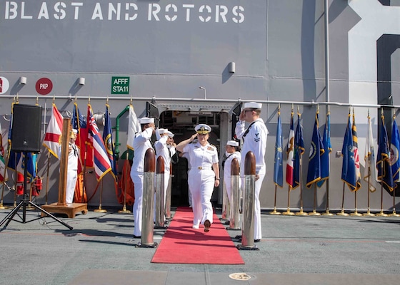 Capt. Jennifer Ellinger, offgoing Commodore of Commander Amphibious Squadron SEVEN (CPR 7), salutes the sideboys during a change of command and reitrment ceremony aboard amphibious assault ship USS Makin Island (LHD 8), July 21.