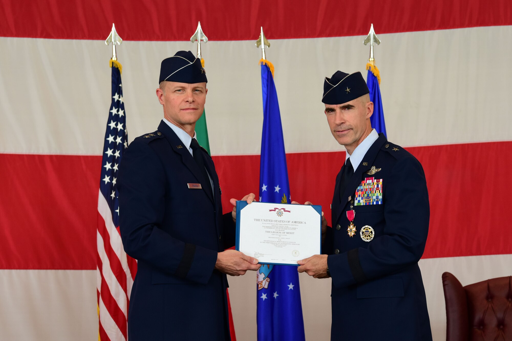 U.S. Air Force Maj. Gen. Derek C. France, 3rd Air Force commander, left, awards the Legion of Merit to Brig. Gen. Jason Bailey, 31st Fighter Wing outgoing commander, right, during the 31st FW change of command ceremony at Aviano Air Base