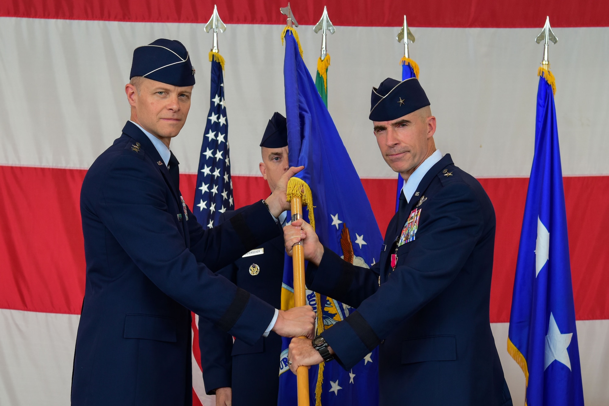 U.S. Air Force Brig. Gen. Jason Bailey, 31st Fighter Wing outgoing commander, right, relinquishes command to Maj. Gen. Derek C. France, 3rd Air Force commander, during the 31st FW change of command ceremony at Aviano Air Base
