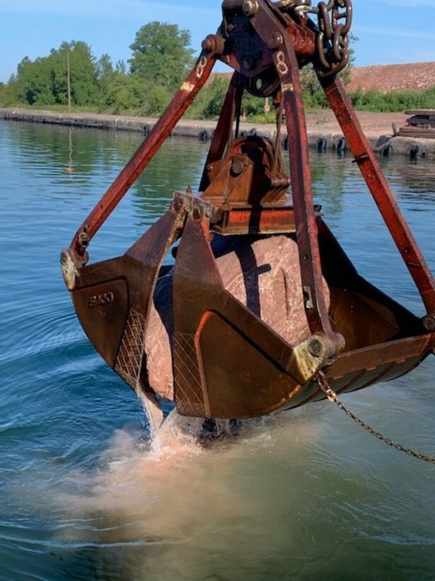 Trade West Inc., of Nevada removes the last rock from the New Lock at the Soo upstream channel deepening project in Sault Ste. Marie, Mich.