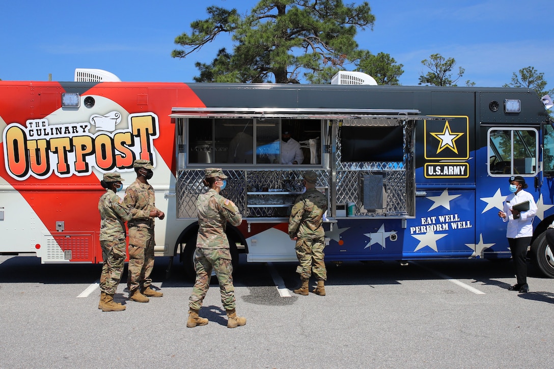 Soldiers gather by a food truck.