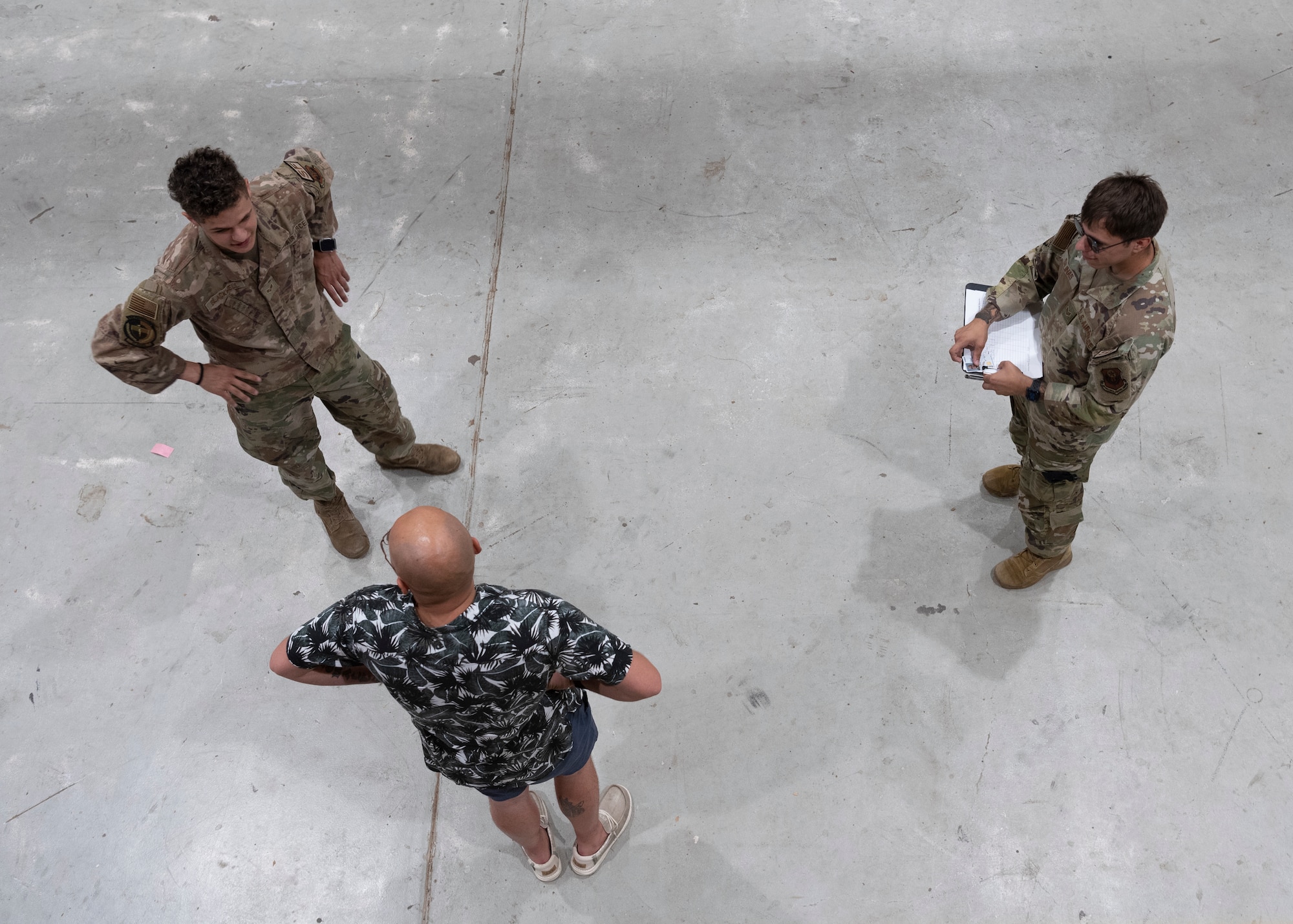 Two Airmen administer a sobriety test to a third person.