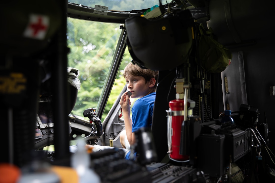 A camper sits front seat in a Blackhawk brought in by The Kentucky National Guard (KYNG) at the KYNG Child and Youth Camp at the Lake Cumberland 4-H Camp in Nancy, Ky. on July 18-22, 2022. The Kentucky National Guard brought in serveral aircrafts for the campers to enjoy. (U.S. Army phot by Pfc. Georgia Napier)