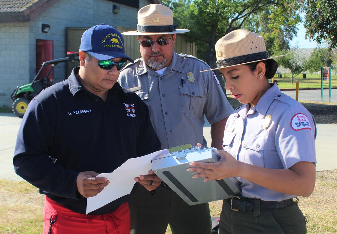 LA County Parks and Recreation Senior Lake Lifeguard Oscar Villagomez, U.S. Army Corps of Engineers Los Angeles District Park Rangers Robert Moreno and Annel Monsalvo, review their scripts for the joint safety video production in Santa Fe Dam Recreational Park June 1 in LA County.