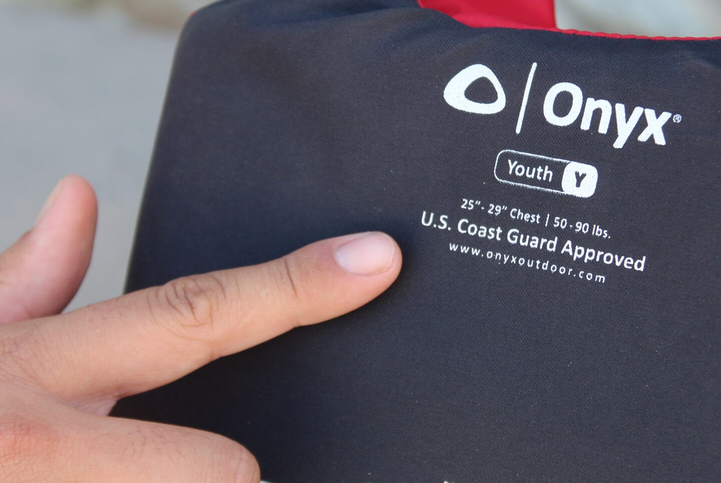 A lifeguard points to the standard label markings of a life jacket Santa Fe Dam Recreational Park June 1 in LA County.