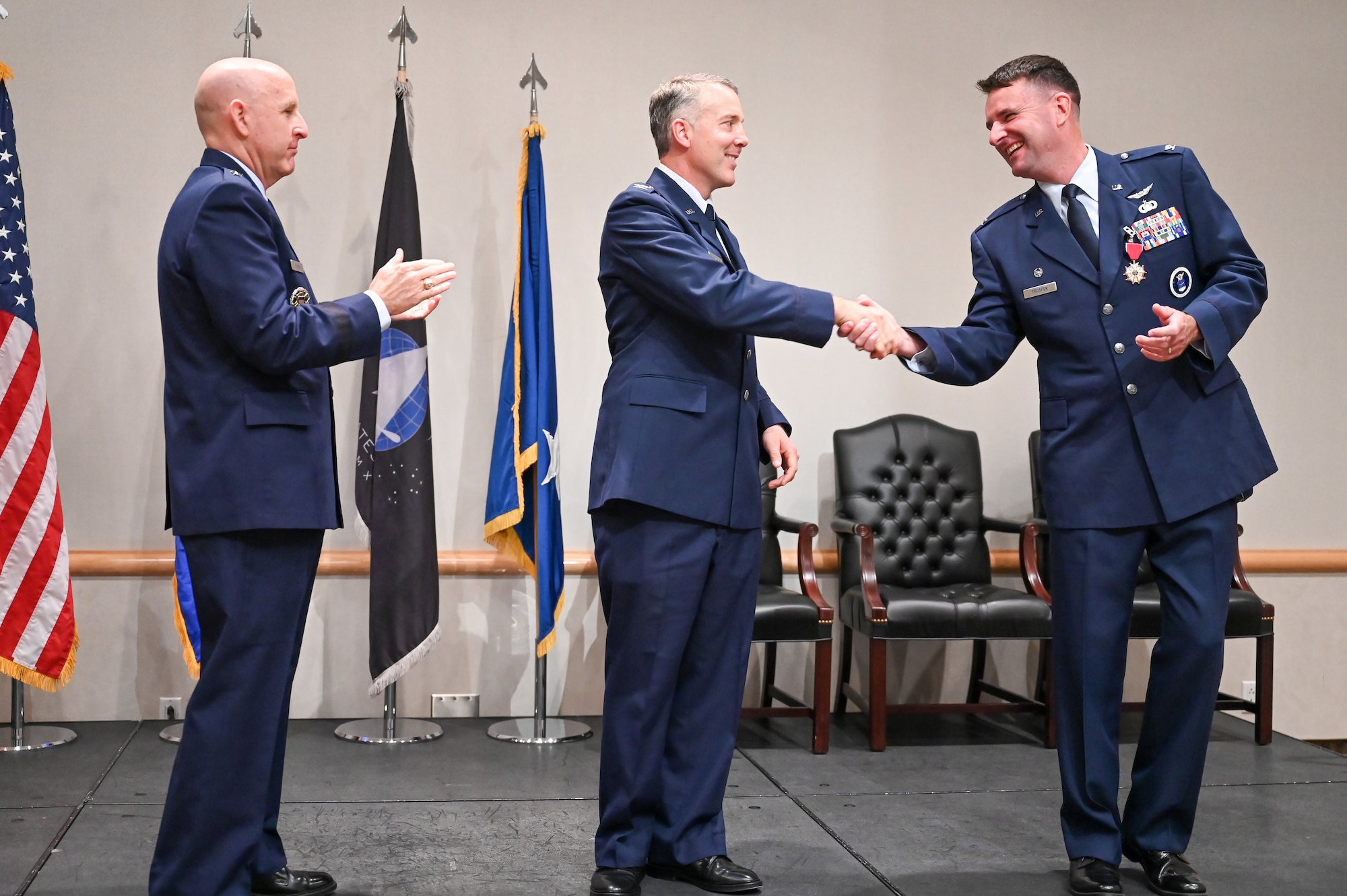 Middle, Col. Joseph J. Egresits, incoming 372nd Recruiting Group commander, shakes the hand of the outgoing 372nd RCG commander, Col. Layne D. Trosper, during a change of command ceremony