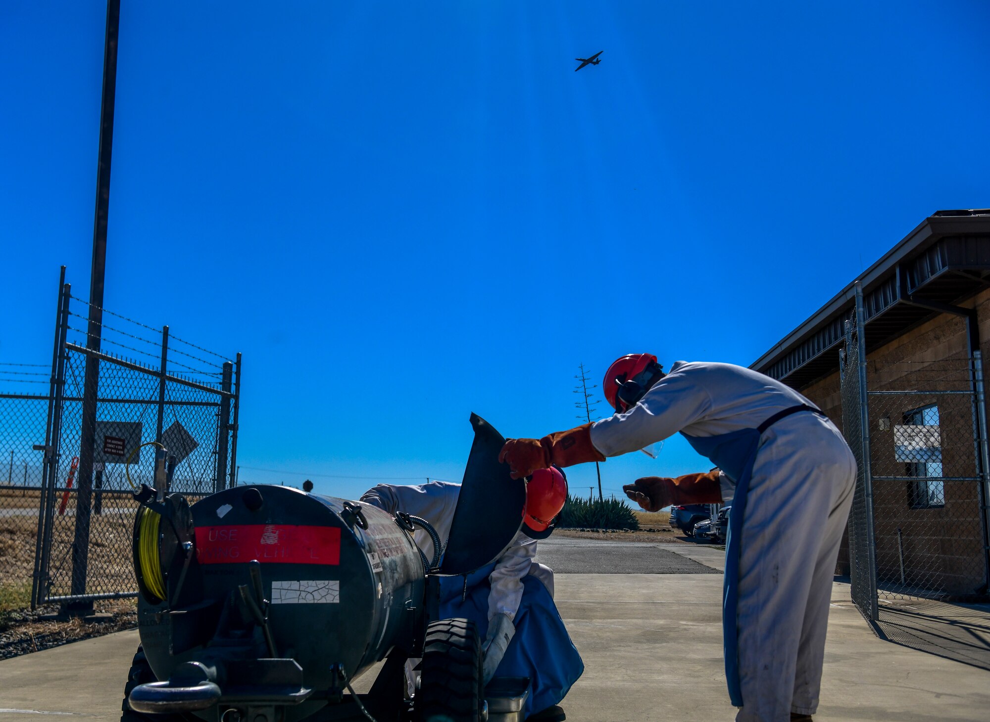 Senior Airman Verdes Cato, observes Airman 1st Class Randy Willis 9th Logistic Readiness Squadron cryogenics technician, as he carefully handles Liquid Oxygen (LOX), while a U-2 Dragon Lady flies over at Beale Air Force Base, California, July 21, 2022.