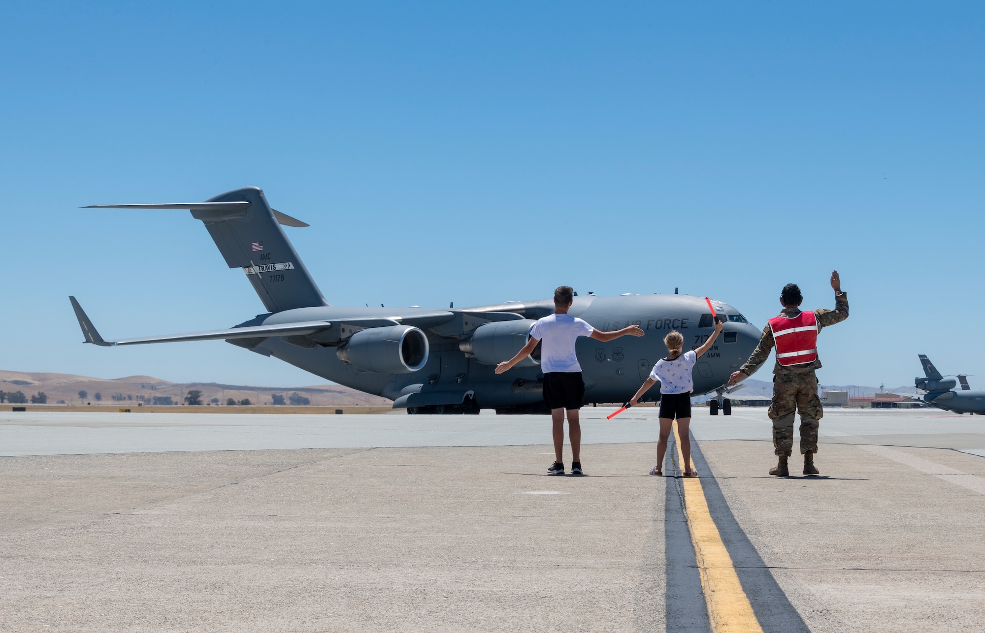 People marshal in an airplane on the flightline.