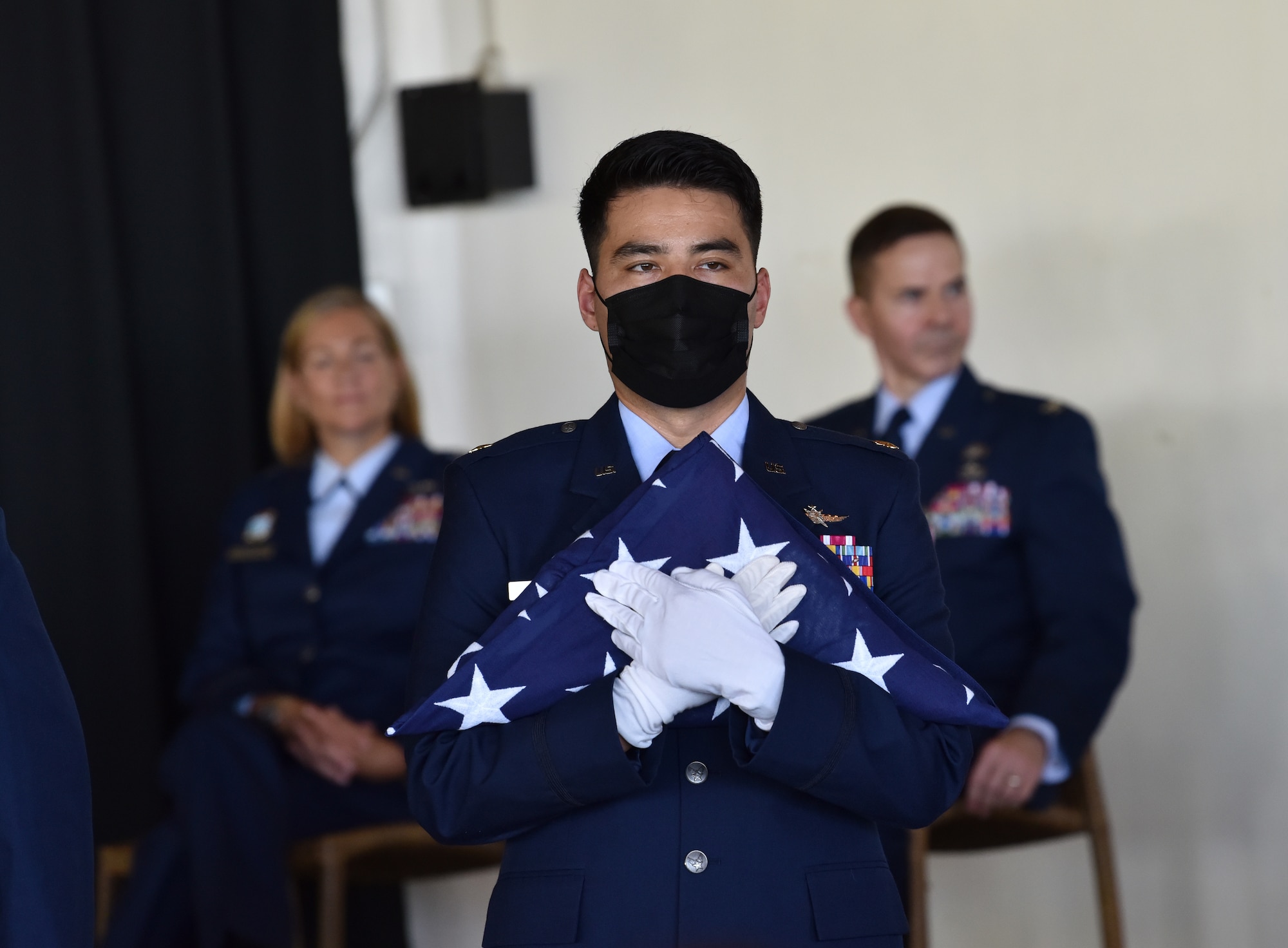 U.S. Air Force Maj. Vincent Taylor, 56th Air Communications Squadron director of Operations, holds a folded U.S. flag as part of a presentation during his father’s, Col. Ralph “Eddie” Taylor, Pacific Air Forces director of Manpower, Personnel and Services, retirement ceremony at Joint Base Pearl Harbor-Hickam, Hawaii on July 15, 2022. Vincent and his father have shared two assignments together throughout their careers. (U.S. Air Force photo by Master Sgt. Joshua Williams)