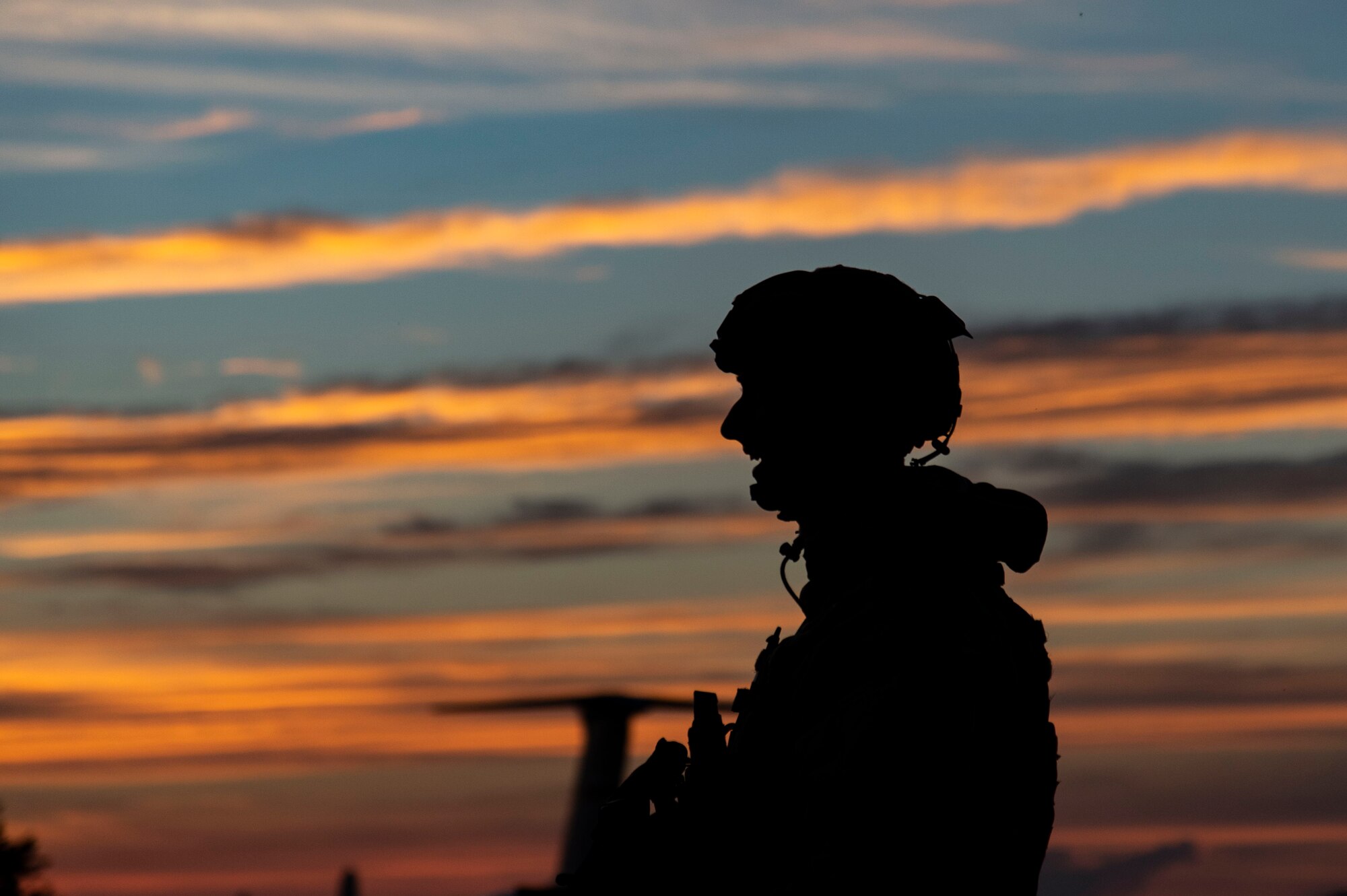 A Team Dover member stands guard at sunset during Liberty Eagle Readiness Exercise 2022 at Dover Air Force Base, Delaware, July 13, 2022. The 436th and 512th Airlift Wings tested their ability to generate, employ and sustain airpower across the world in a contested and degraded operational environment. (U.S. Air Force photo by Roland Balik)