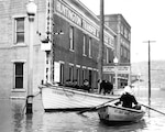 Coast Guardsmen set up floating command post tied to a lamppost and dispatch personnel by dinghy to the flooded town. (U.S. Coast Guard)