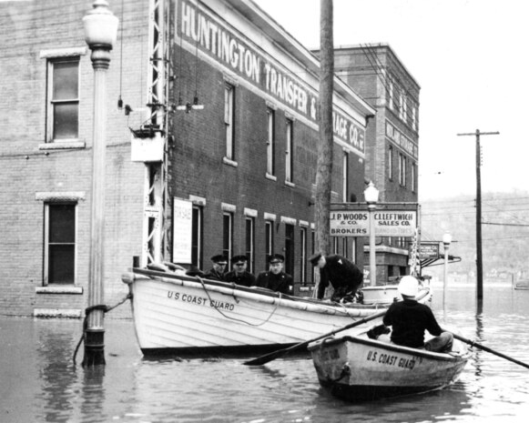 Coast Guardsmen set up floating command post tied to a lamppost and dispatch personnel by dinghy to the flooded town. (U.S. Coast Guard)