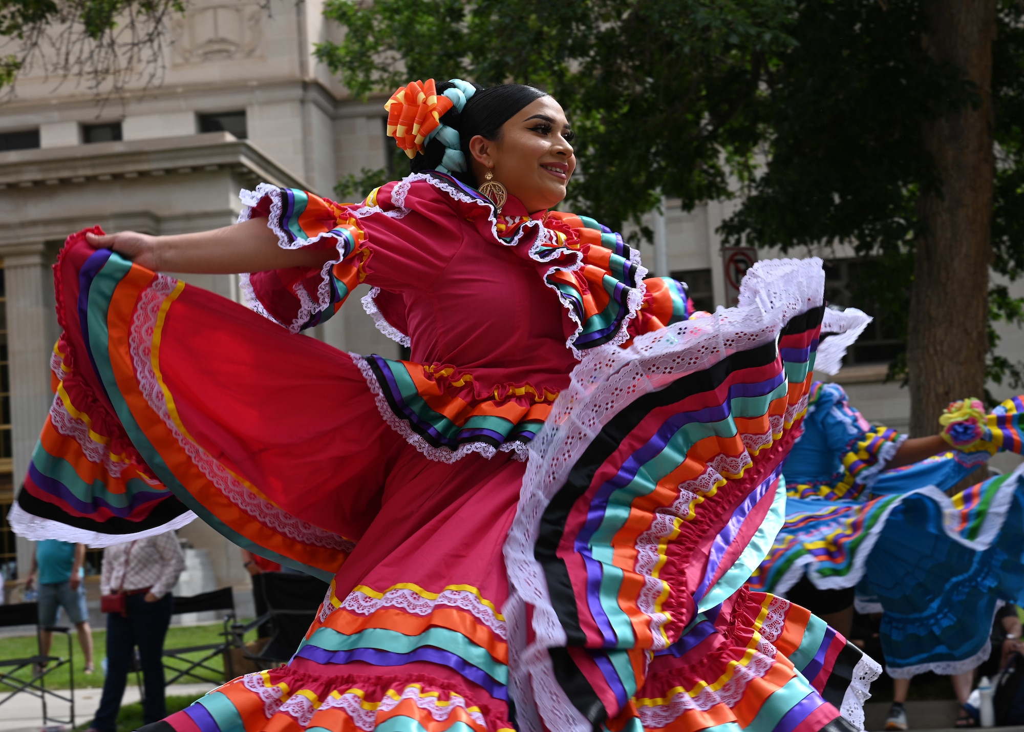 A dancer dances and flourishes her dress during the Cheyenne Frontier Days grand parade, July 23, 2022 in Cheyenne, Wyoming. This year marks the 153rd anniversary of F.E. Warren Air Force Base and the city of Cheyenne, who came together to celebrate the 126th CFD rodeo and festival, as well as the Air Forces 75th birthday. CFD runs from July 22 - 31. (U.S. Air Force photo by Senior Airman Darius Frazier)