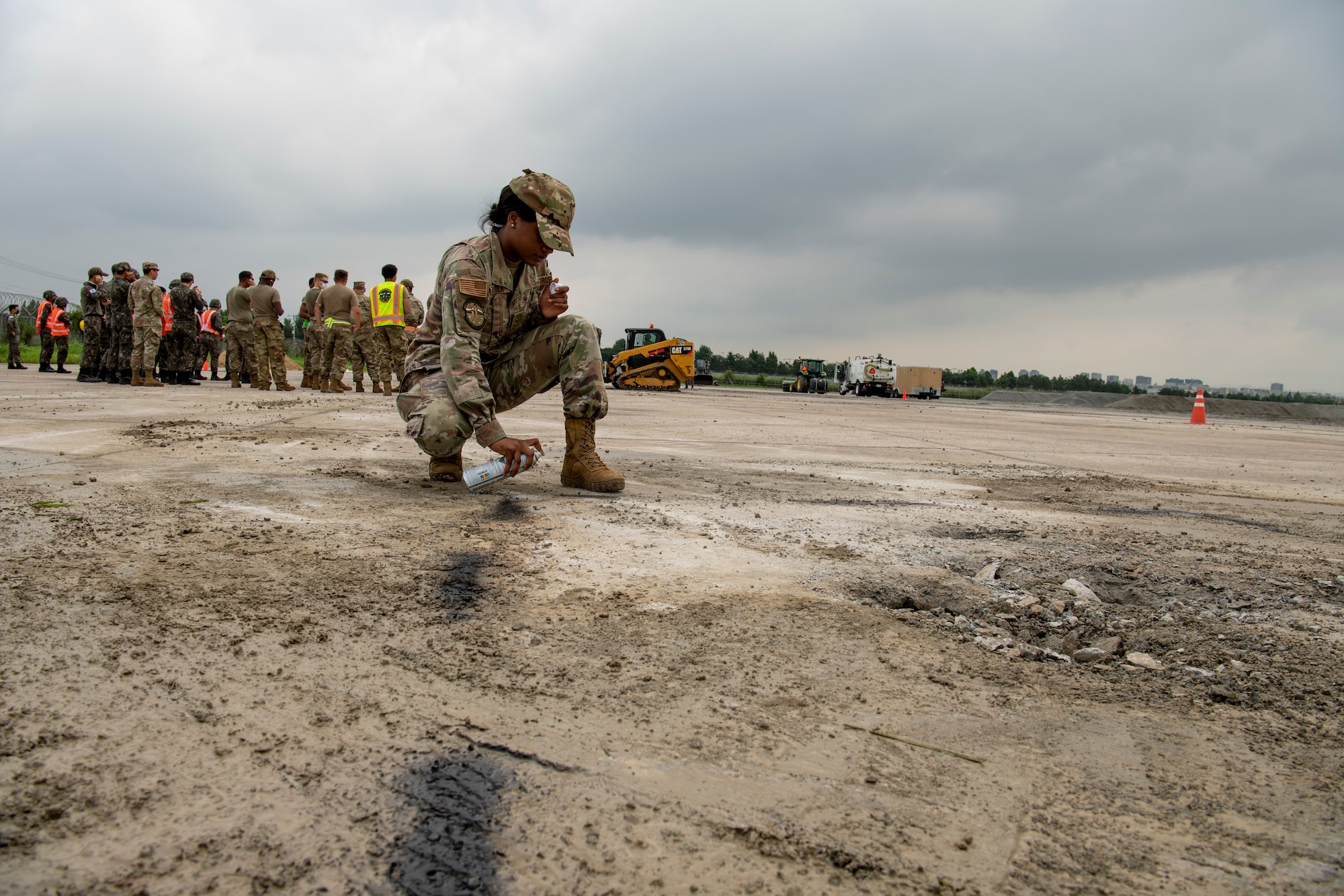 U.S. Air Force Senior Airman Tamayia Woolfolk, an Engineering Assistant Journeyman, performs upheaval marking using spray paint during rapid airfield damage repair training, July 19, 2022 at Gwangju Air Base, Republic of Korea.