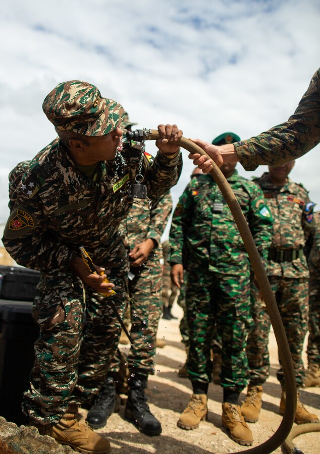 Lt. General Falur Rate Laek, the Chief of Defense for Timor-Leste, drinks water freshly purified by a U.S. Marine Corps water purification system belonging to the Logistics Combat Element, Marine Rotational Force-Darwin 22, during a Humanitarian Aid and Disaster Relief (HADR) exercise at the Baucau Airport, Baucau, Timor-Leste, June 28, 2022. MRF-D 22 conducted the HADR exercise in order to reassure regional allies and partners of the force's capacity to respond to crises within the Indo-Pacific. (U.S. Marine Corps photo by Cpl. Cedar Barnes)