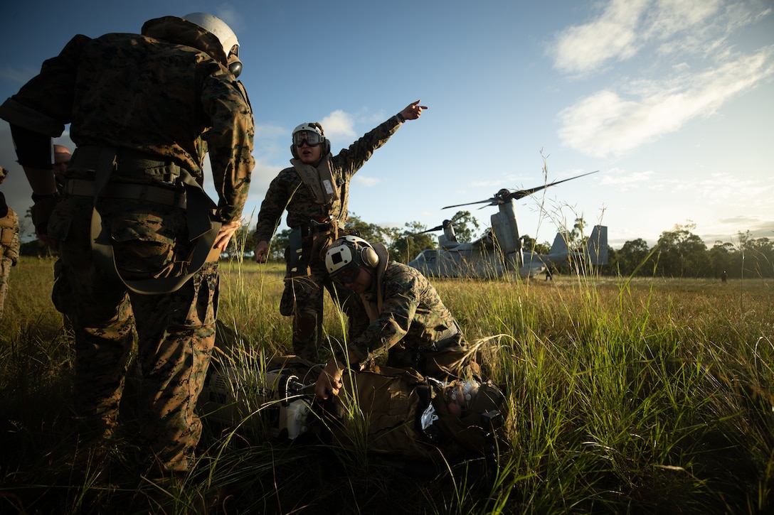 U.S. Navy Corpsman with Marine Rotational Force-Darwin (MRF-D) 22, prepare to load U.S. Marines Corps Lance Cpl. Michael Define, an optics technician with Headquarters and Support Company, 3d Battalion, 7th Marines, Ground Combat Element, MRF-D 22, roleplaying as a friendly casualty, into an MV-22 Osprey with the Aviation Combat Element (ACE), MRF-D 22, during a long-range casualty evacuation as part of exercise Southern Jackaroo 22 at Shoalwater Bay Training Area (SWBTA), Queensland, Australia May 24, 2022. The MRF-D 22 ACE’s MV-22 Ospreys traveled from Darwin, NT, Australia to SWBTA to conduct the long-range CASEVAC drill. (U.S. Marine Corps Photo By Cpl. Cedar Barnes)