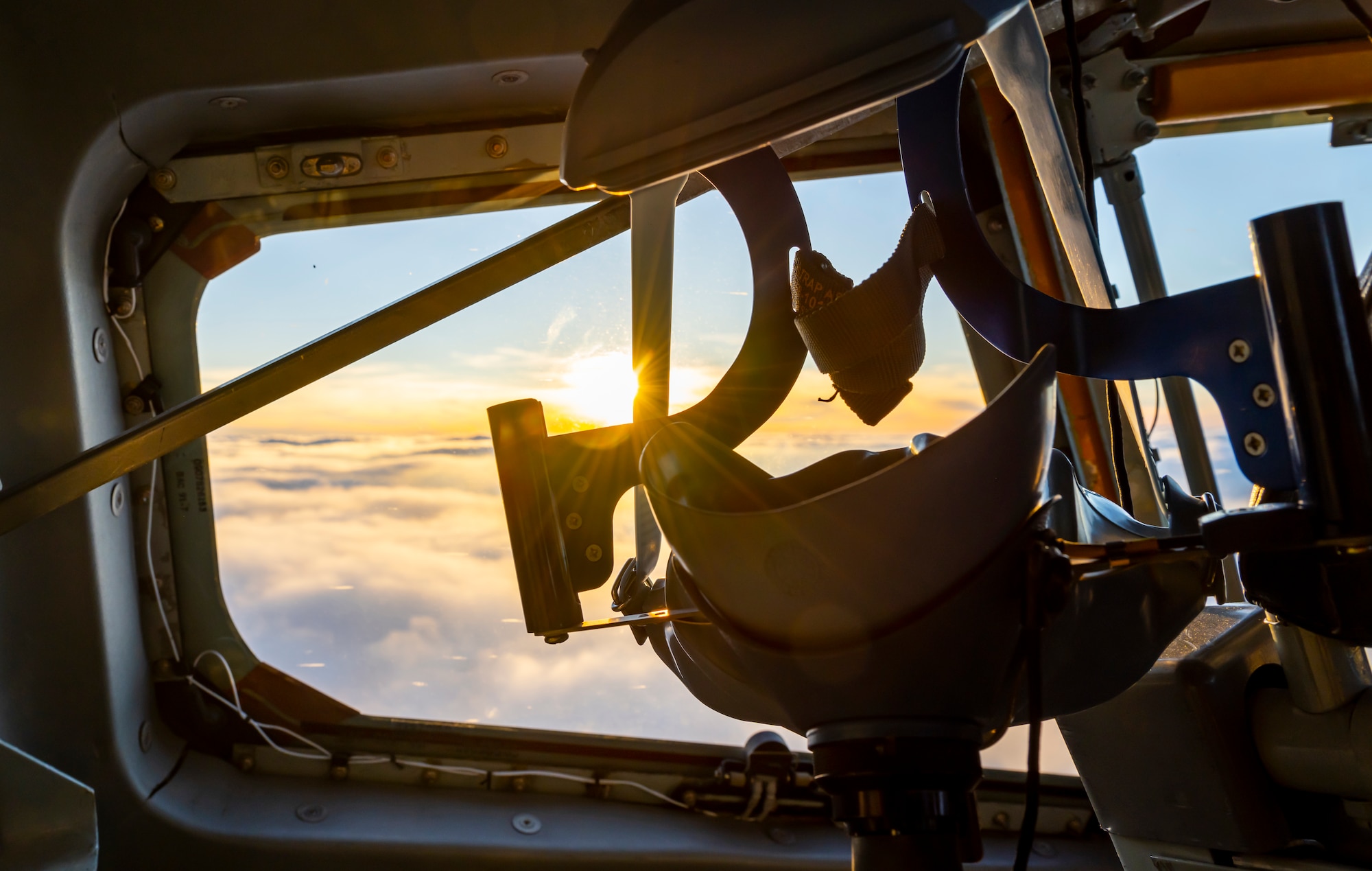 The sun sets over the North Sea horizon through the window of a KC-135 Stratotanker aircraft assigned to the 100th Air Refueling Wing at Royal Air Force Mildenhall, England, during a refueling mission, July 21, 2022. The 100th Air Refueling Wing uses the KC-135 to continuously provide the critical air refueling bridge that allows the Expeditionary Air Force to deploy around the globe in a moments notice.