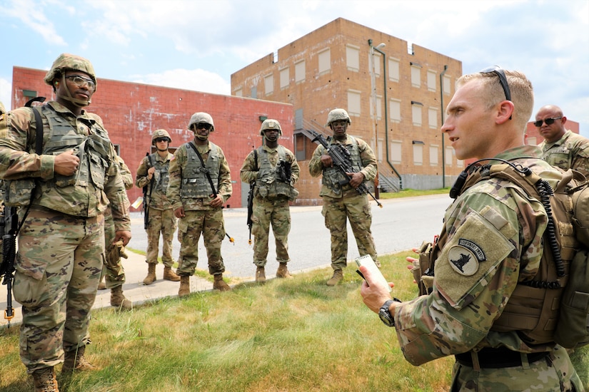 Staff Sgt. Brandon Kelly (right), training NCO of the 160th Engineer Company, Delaware Army National Guard provides feedback to his Soldiers after having completed a squad training lane at the Combined Arms Collective Training Facility of Fort Indiantown Gap, Pa. July 12, 2022 during the company’s annual training.