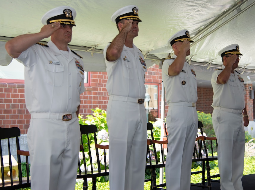 NEWPORT, R.I. (July 22, 2022) Members of the official party salute while the national anthem plays during the Navy Supply Corps School (NSCS) change of command ceremony at Naval Station Newport, July 22.  NSCS prepares newly commissioned Supply Corps officers from the U.S. Naval Academy, Officer Candidate School and Naval Reserve Officers Training Corps, as well as limited duty officers or officers who have been re-designated into the community, to serve in the fleet in entry-level positions. (U.S. Navy photo by Mass Communication Specialist 2nd Class Derien C. Luce)
