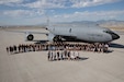 High school students stand in front of a KC-135 Stratotanker airplane for a group photo.