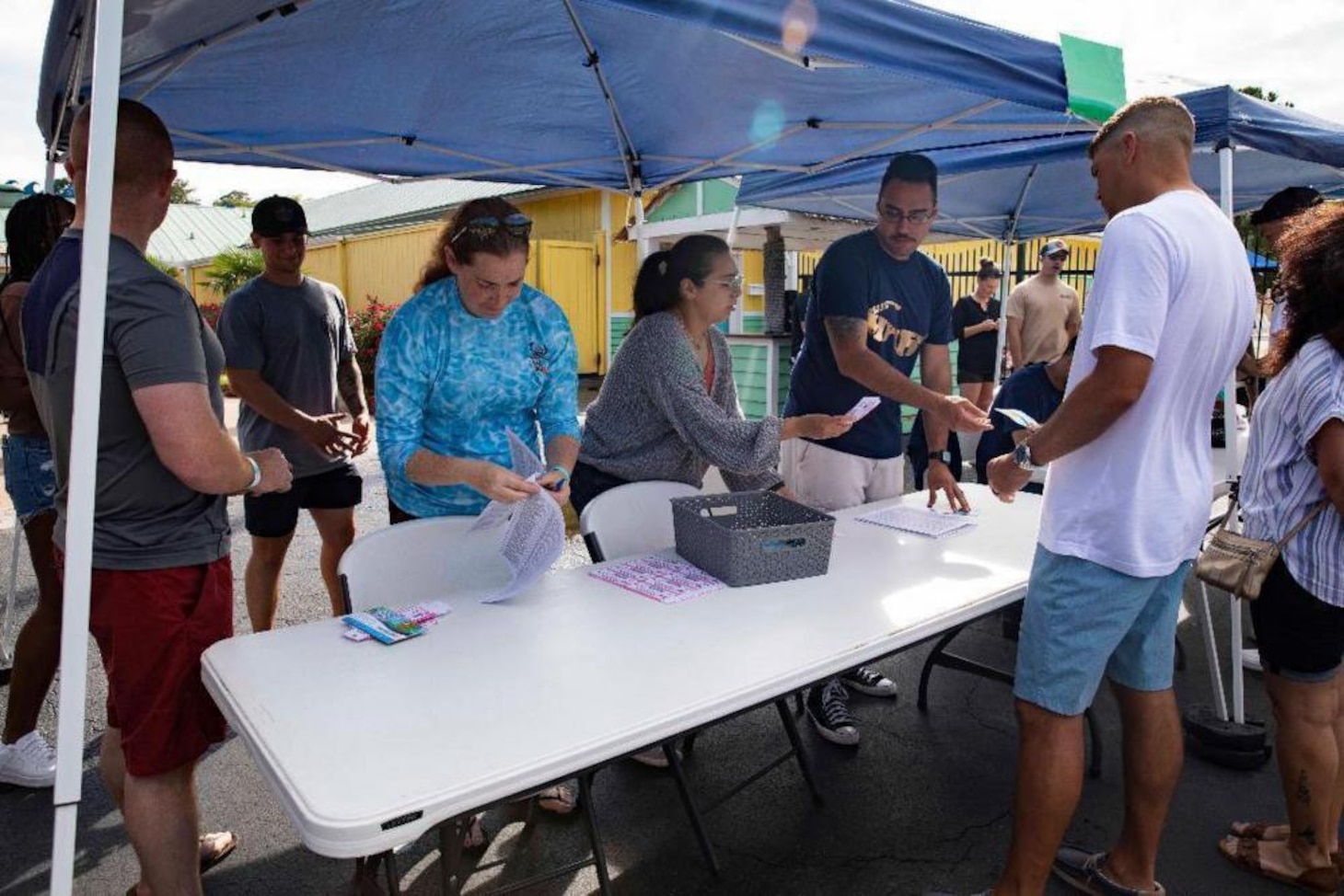 Sailors from the amphibious assault ship USS Wasp (LHD 1) check in personnel at the front gate of Ocean Breeze Waterpark for the command's summer picnic, June 23.