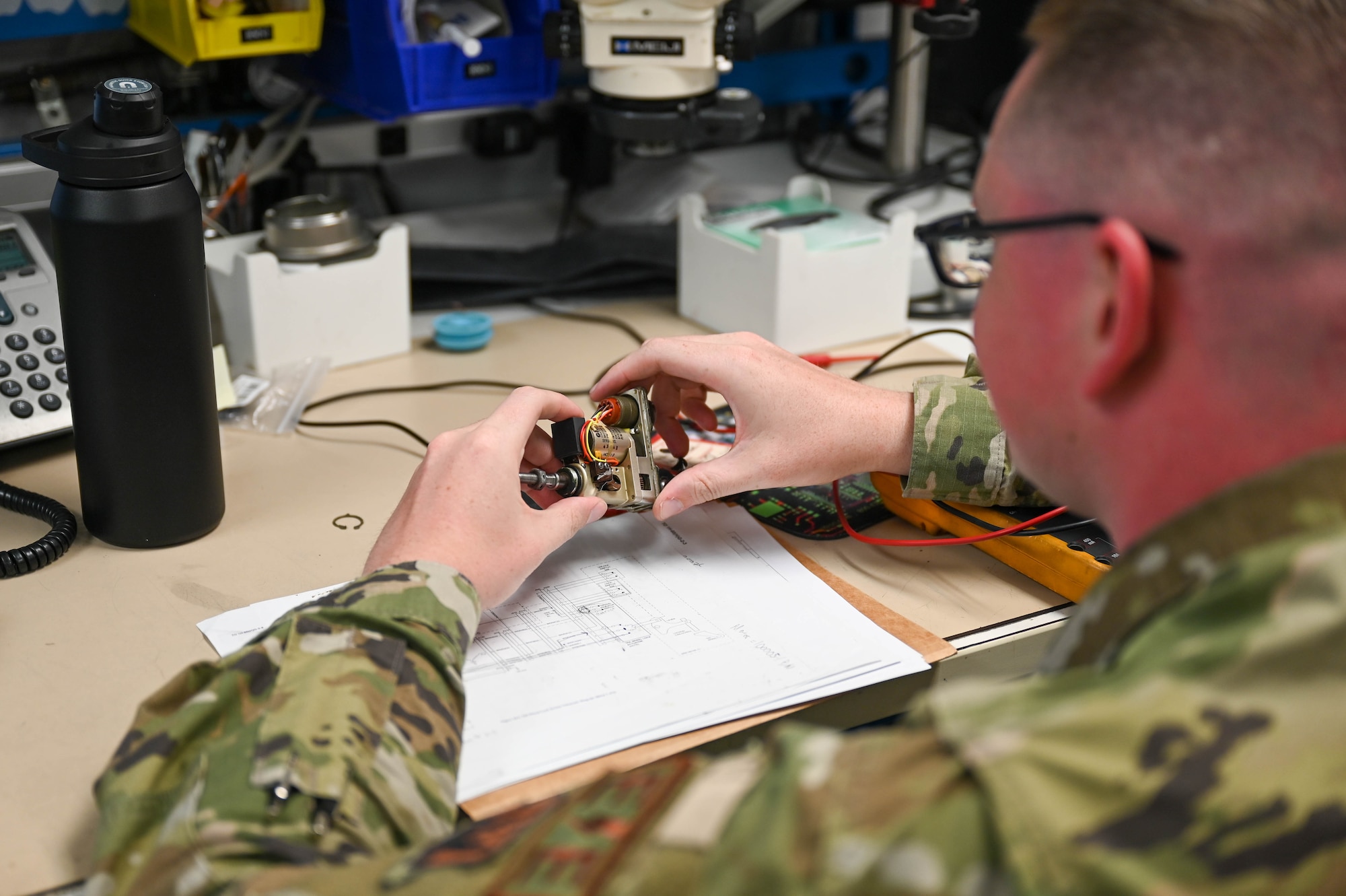 A photo of an Airman tinkering with a part.